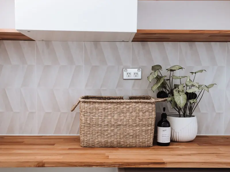 Cesto de mimbre y una planta sobre una encimera de madera